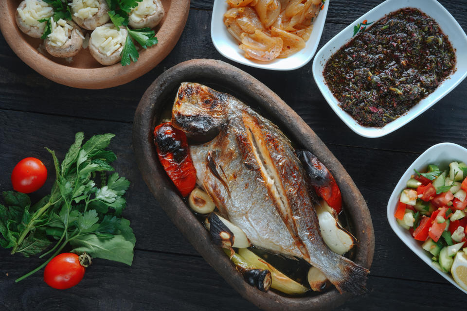 Fresh fish on a black wooden board. Raw raw sea bream on a black plate.